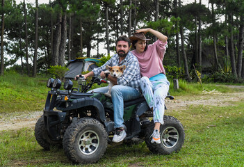 Portrait of young married couple sitting on a quad bike in the forest © Tatiana
