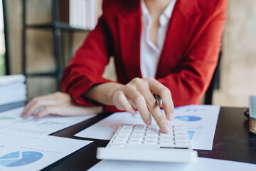 Obraz premium Young asian female work with financial papers at home count on calculator before paying taxes receipts online, planning budget glad to find chance for economy saving money, audit concepts