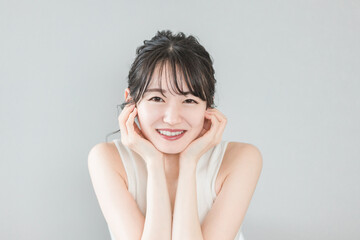 白い歯が美しい笑顔のアジア人女性（ホワイトニング・歯列矯正）
