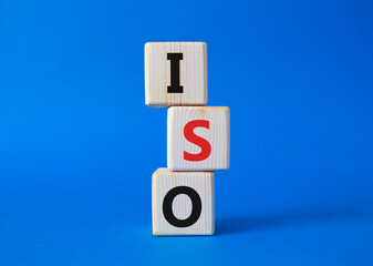 ISO standards quality control symbol. Concept word ISO on wooden cubes. Beautiful blue background. Business and ISO concept. Copy space.