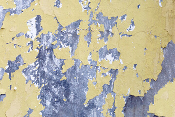 Cracked yellow paint on cement wall