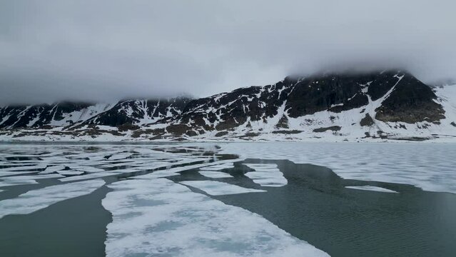Flying over the arctic ocean by the Svalbard archipelago coastline.