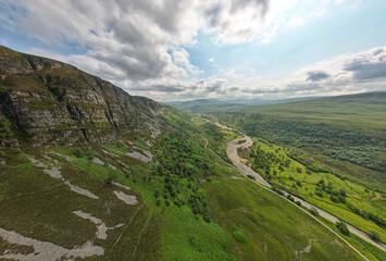 Aerial view of the Riddoroch Valley near Ullapool, showcasing the vast wilderness under a cloudy summer sky.