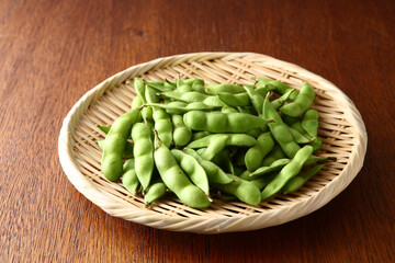 笊に盛った生の枝豆　木目背景