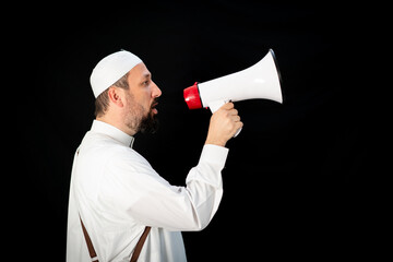 Handsome man with beard shouting through megaphone for Hajj in Mekkah