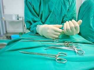 Surgeon suturing the skin of the abdominal wound wiyh subcuticular technique