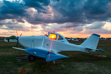 White agricultural aircraft against the backdrop of a scenic sunrise