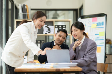 Asian business presents to explain the graph work on the whiteboard. Consulting, discussing, exchanging knowledge.