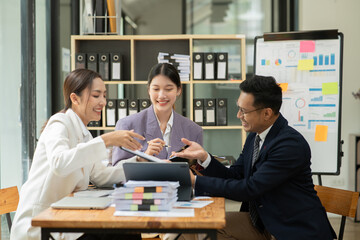 Asian business presents to explain the graph work on the whiteboard. Consulting, discussing, exchanging knowledge.