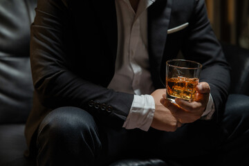 Businessman sitting Holding a Glass of Whiskey Drink Whiskey in the liquor store room
