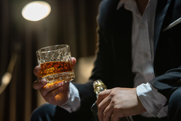 Businessman sitting Holding a Glass of Whiskey Drink Whiskey in the liquor store room