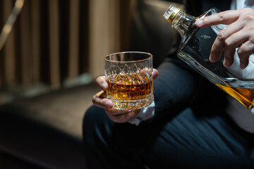 Businessman sitting Holding a Glass of Whiskey Drink Whiskey in the liquor store room