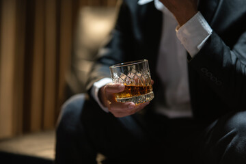 Businessman sitting Holding a Glass of Whiskey Drink Whiskey in the liquor store room