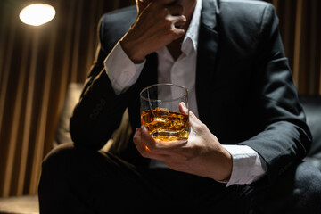 Businessman sitting Holding a Glass of Whiskey Drink Whiskey in the liquor store room