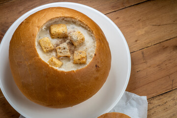 Cream Of Mushroom Soup with Bread bowl on wooden background.