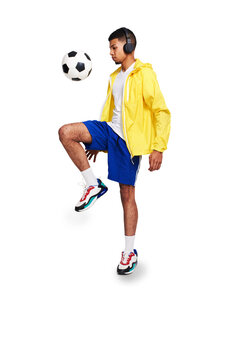 Isolated young man, kicking soccer ball and headphones with music by transparent png background. Young football player, juggle and listening with audio tech for streaming service, fitness and sports