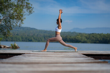 Fototapeta na wymiar Fitness Asian woman doing yoga in park, Young woman practicing yoga, female happiness in landscape background, Lifestyle of exercise and pose for relax healthy life in the morning nature outdoor