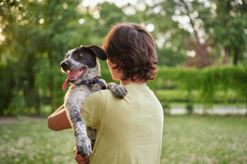 Outdoor portrait of boy with his adopted dog. Friendship of teenager with pet, boy walking in...