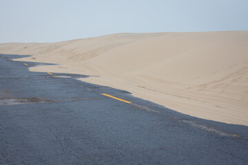 Sand dunes spilling over into road