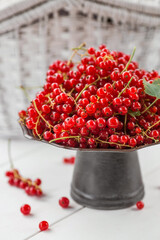 Fruits and berries. Summer time. Delicious red currants on a stylish iron tray in retro style on a white table. Space for text.