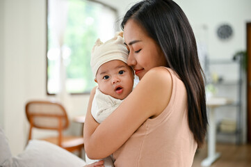 Young Asian mother holding her child in her loving arms.