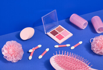 Cosmetics and make up acessories. Eye shadow, hair curler, comb and cosmetic sponge.