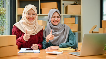 Young muslim online business team working together, showing a thumbs up sign. good job