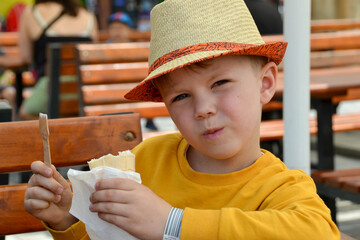 Close up image of BOY hand holding fresh waffle cone with vanilla