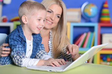 mother and son using modern laptop