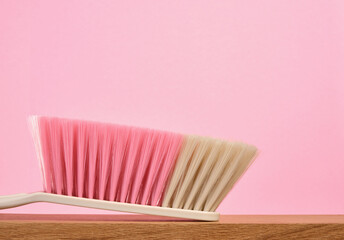 Cleaning supplies on a wooden table. Brush with thick natural bristles in different colors. Copy space for text.