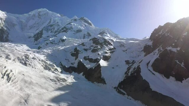 Aerial footage, Rakaposhi Pakistan. Rising shot of snow-covered mountain range. Karakoram mountain range in the Gilgit-Baltistan territory. Drone shot.