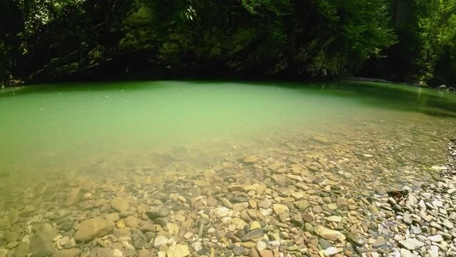 Creek and stony shore of mountain river Khosta in Caucasus mountains