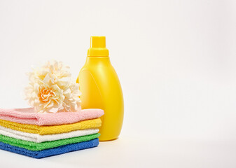 Colorful bright composition of clean towels and laundry detergent in a yellow bootle. Copy space...
