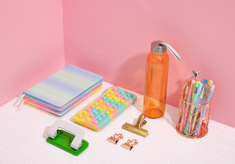 Colorful creative school supplies. Shaker for water, pencil case pop it, stapler, clamp, color notebooks and other stationery.