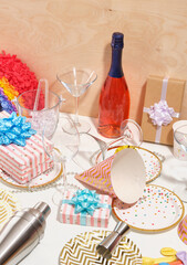 Concept of party and celebration. Detail of cocktail party table. Alcohol, glasses for different drinks, dinnerware festive, metal shaker and jigger.