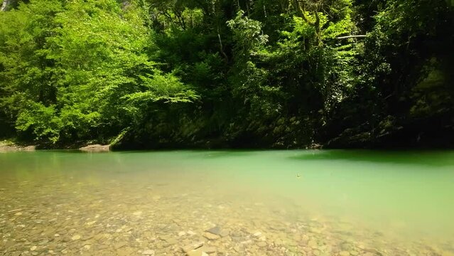 Stony Khosta river in Caucasus mountains in sunny day. Tilting up