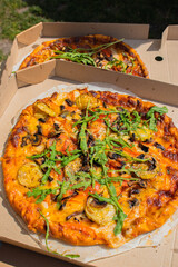 Two pan pizzas in two pizza boxes with their two different flavors