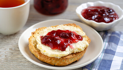 Traditional british scones with clotted cream and strawberry jam for tea time