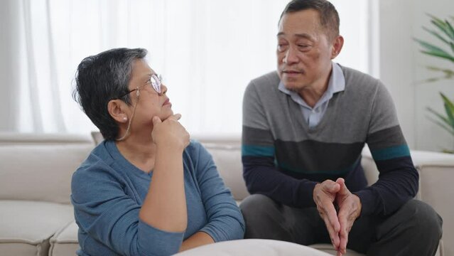 Elderly asian couple talking and spending time together in living room at home. Asian senior couple relax at home. Couple retirement lifestyle