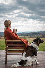The setter dog sitting next to his owner on the outdoor