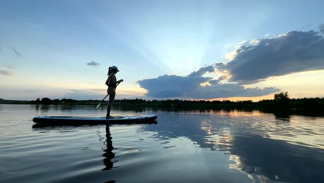 beautiful woman on sunset in the middle of the lake