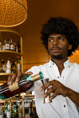 vertical photo of a latin bartender with curly hair preparing a cocktail