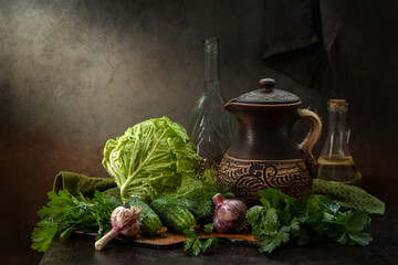 Rustic still life with vegetables, herbs and a jug on a dark background