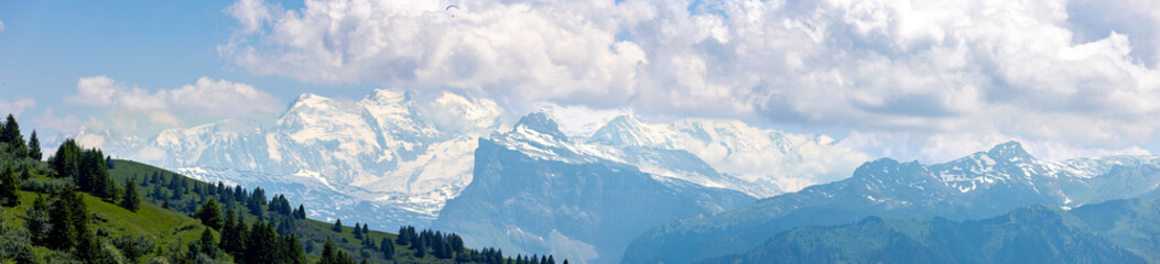 Wide panorama of Mont Blanc Massive eternal snow tops in atmospheric haze with dramatic clouds...