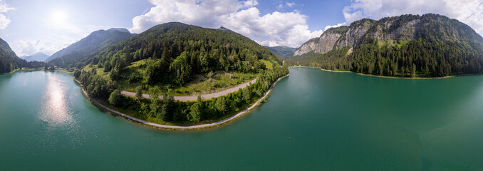 360 degrees panorama of Lac Montriond seen from above. Aerial of French Alps mountain range melt water lake in summer. - obrazy, fototapety, plakaty