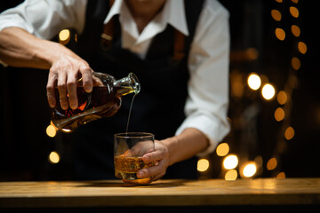 Bartender pours whiskey to customer in tavern - obrazy, fototapety, plakaty