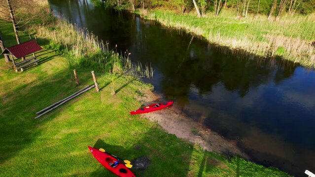 A red kayak standing on the shore of a wild river, Hańcza
