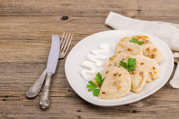 Dumplings, filled with cabbage. Fried onion, fresh sour cream. Traditional Ukrainian dish
