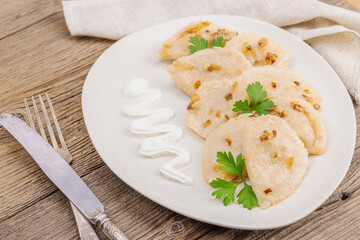 Dumplings, filled with cabbage. Fried onion, fresh sour cream. Traditional Ukrainian dish