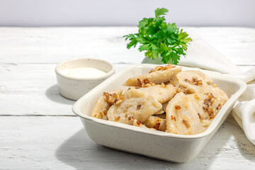 Dumplings, filled with cabbage. Fried onion, fresh sour cream. Traditional Ukrainian dish